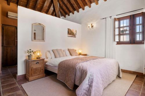 een slaapkamer met een bed en een spiegel aan de muur bij Hacienda Riogordo in Ríogordo