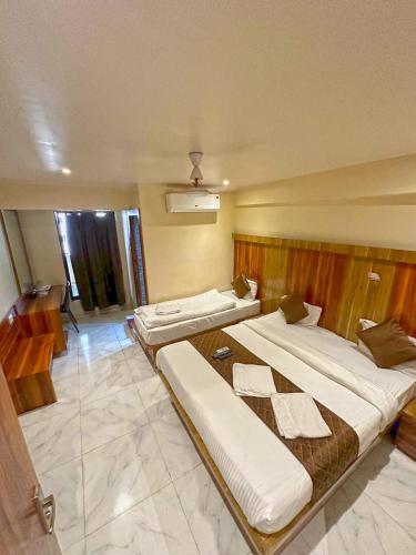 a room with two large beds in it at Hotel Mourya Residency in Navi Mumbai