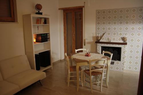 een eetkamer met een tafel en stoelen en een open haard bij A&I Holiday House in Castelnuovo di Porto