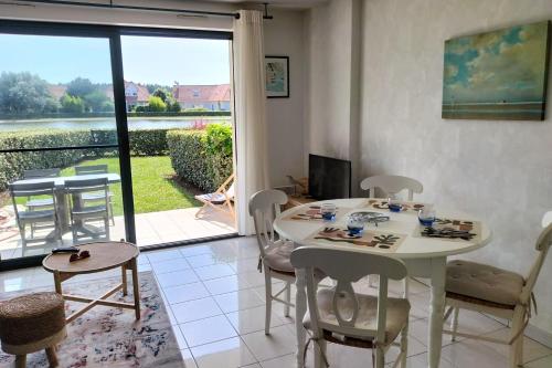 un salon avec une table et des chaises blanches dans l'établissement T2 Quiet and green with garden, à Merlimont