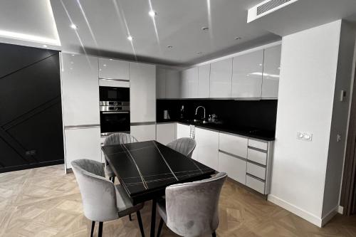 - une cuisine noire et blanche avec une table et des chaises dans l'établissement Elegant air-conditioned apartment near the beach, à Antibes