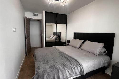 une chambre avec un grand lit avec des oreillers blancs dans l'établissement Elegant air-conditioned apartment near the beach, à Antibes