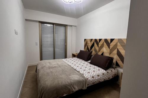 une chambre avec un grand lit et une fenêtre dans l'établissement Elegant air-conditioned apartment near the beach, à Antibes