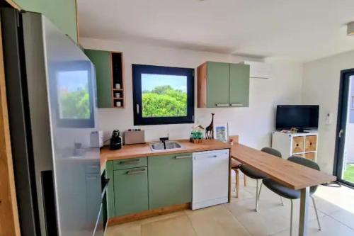une cuisine avec des placards verts et une table en bois dans l'établissement House 3 rooms with terrace, à Sainte-Marie-la-Mer
