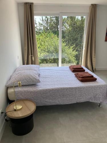 une chambre avec un grand lit avec une fenêtre dans l'établissement logement spacieux idéal pour famille, à Vence