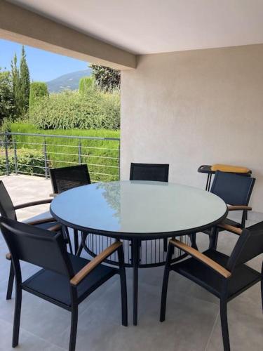 une table et des chaises assises sur une terrasse dans l'établissement logement spacieux idéal pour famille, à Vence