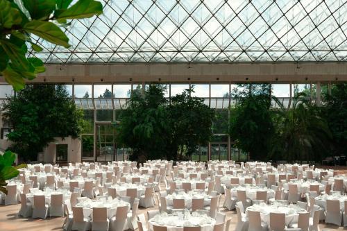 a large room with white tables and chairs at Eventhotel Pyramide in Vösendorf