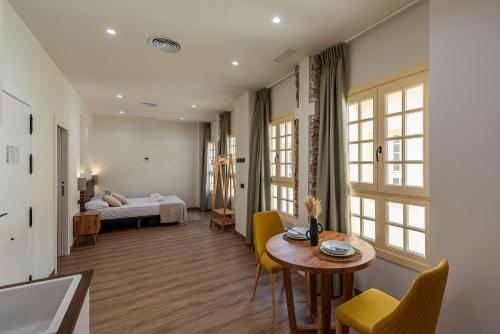 una habitación con una cama, una mesa y sillas en iloftmalaga Pasaje Chinitas, en Málaga