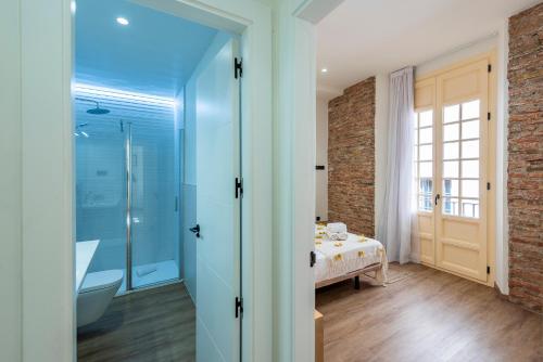 baño con cama y puerta de cristal en iloftmalaga Pasaje Chinitas, en Málaga
