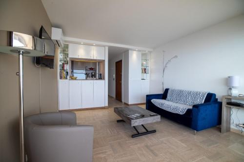un salon avec un canapé bleu et une table dans l'établissement Beautiful apartment with Sea View perfect for Holidays and Festivals, à Cannes
