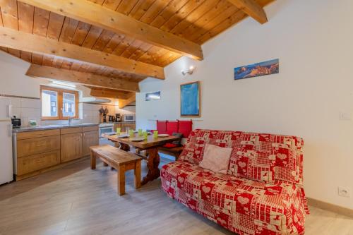 un salon avec un canapé rouge et une table dans l'établissement Appartement Grand Roc 2 - 241 - Happy Rentals, à Chamonix-Mont-Blanc