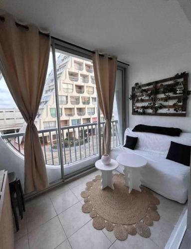 un salon avec un canapé et une grande fenêtre dans l'établissement Studio La Grande Motte with balcony and view, à La Grande Motte