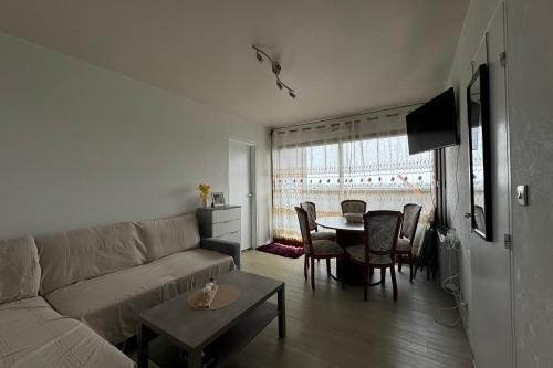 un salon avec un canapé et une table avec des chaises dans l'établissement Nice T2 close to the beach of Cabourg, à Cabourg