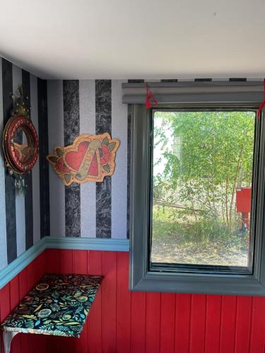 a room with a window and a red wall at Grand Circus Hotel in Malmö