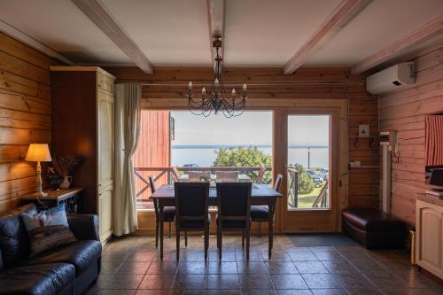 a dining room with a table and chairs and a large window at Vėtrungių Namai in Nida