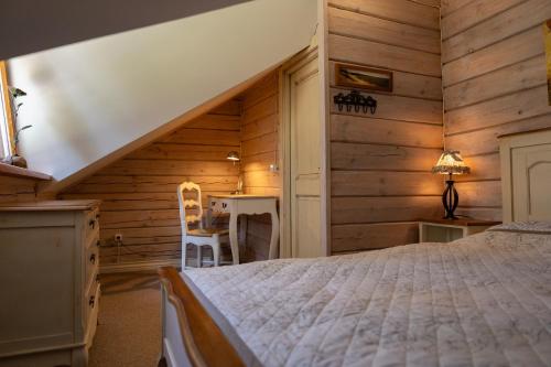 a bedroom with a bed in a room with wooden walls at Vėtrungių Namai in Nida