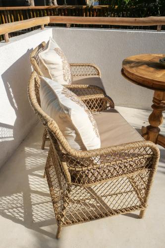 two wicker chairs with pillows on a patio at The Balangan Hotel in Jimbaran