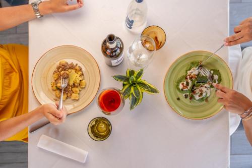 two people sitting at a table with plates of food at Agriturismo dei Grippi in Sona