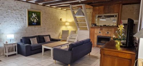 - un salon avec un canapé, une table et une échelle dans l'établissement Ma Demoiselle d'Oé - maison climatisée -3 étoiles, à Notre-Dame-dʼOé