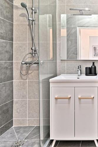 une salle de bain avec une douche avec un lavabo et un miroir dans l'établissement Studio lumineux et moderne à Montreuil - II, à Montreuil