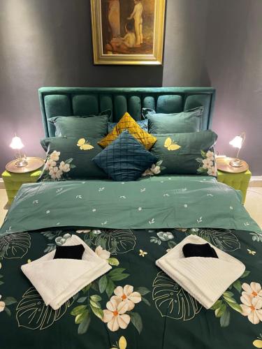 a bedroom with a green bed with towels on it at Apartment Central very close to Aquapark Nymphaea in Oradea