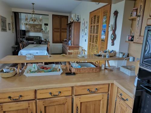 une cuisine avec des armoires en bois et un comptoir dans l'établissement Maison de famille 8-9 personnes, à Saint-Hilaire-Peyroux