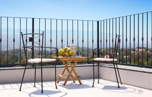 a table with two chairs and a bowl of fruit on a balcony at Cozy Home In Gornja Stubica With Sauna in Gornja Stubica