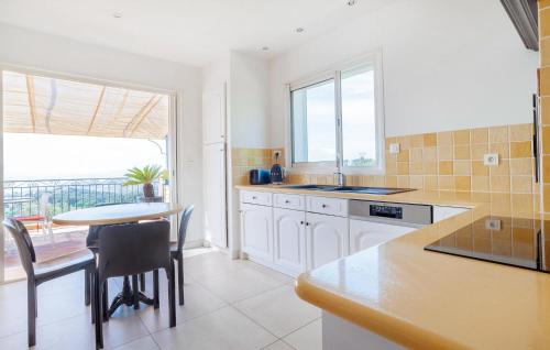 une cuisine avec des armoires blanches et une table et une salle à manger dans l'établissement Lovely Home In Sainte-Maxime With Wifi, à Sainte-Maxime