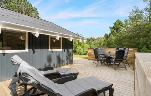 a wooden deck with a table and chairs on it at Amazing Home In Hvide Sande With Wifi in Bjerregård