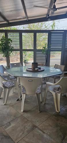 a table and chairs in a patio with a table and chairs at Almost Off Grid Tranquillity in Katherine