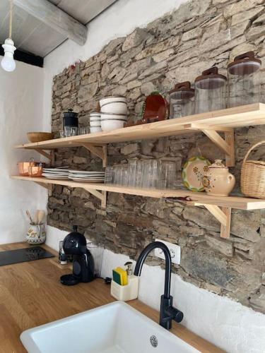 a kitchen with a sink and a stone wall at Olive Tree House in Terena