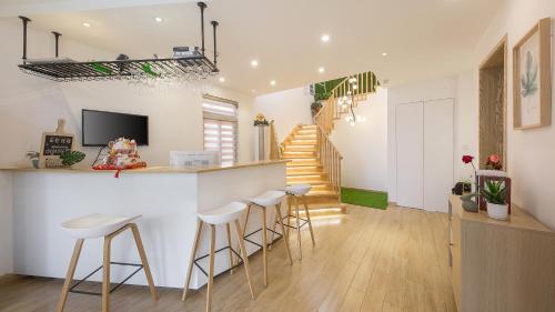 a kitchen and living room with a bar and stools at Dashe Yuanye Boutique Homestay in Xitang