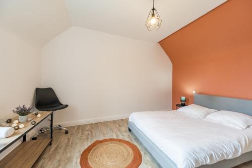 a bedroom with a bed and a desk and a chair at Maison Confortable au coeur de Guingamp in Guingamp