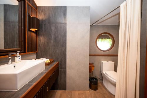 a bathroom with a sink and a toilet at River Kwai Resotel in Sai Yok