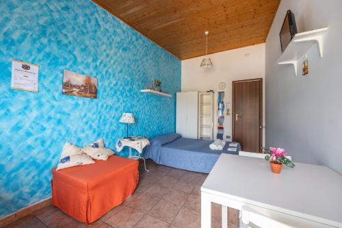 a living room with a couch and a blue wall at Antica Dimora Marinelli in Ficarra