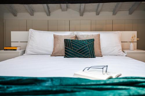a bed with a green blanket and a book on it at Casa delle Note in Modena