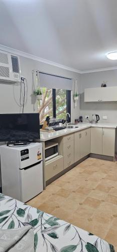 a kitchen with a sink and a stove top oven at Almost Off Grid Tranquillity in Katherine