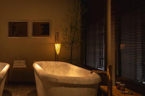 a bath tub in a bathroom with a lamp at The Venice Venice Hotel in Venice