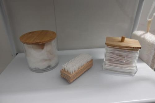 a bathroom counter with a jar of soap and a brush at 2 bedroom with 200m to sea - beach and relax in Paphos City