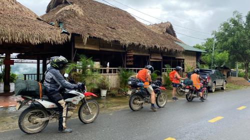 a group of people riding motorcycles down the street at Panoramic Home in Hương Bá Thước