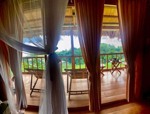 a room with a large window with chairs and a porch at Panoramic Home in Hương Bá Thước