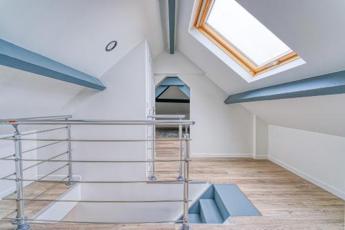 a room with white walls and a skylight at Maison familiale proche Paris in Saint-Maur-des-Fossés