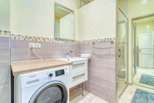 a washing machine in a bathroom with a shower at Maison familiale proche Paris in Saint-Maur-des-Fossés