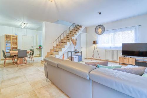 a living room with a couch and a tv at Maison familiale proche Paris in Saint-Maur-des-Fossés