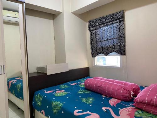 a small bedroom with a bed and a window at Apartemen Center Point Bekasi in Kayuringin