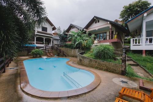 a large swimming pool in front of a house at Kataonsea bungalows in Kata Beach