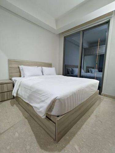 ジャカルタにあるGold Coast USA Room Studio netflixの大きな窓付きのベッドルームの大型ベッド1台