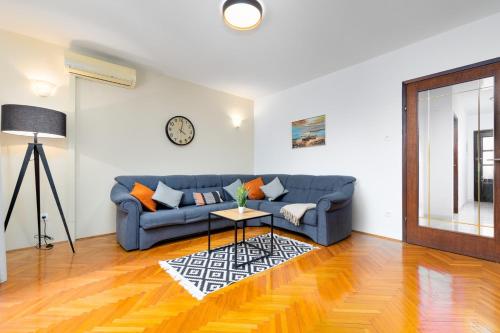 a living room with a blue couch and a table at House Dinka with Pool in Porat