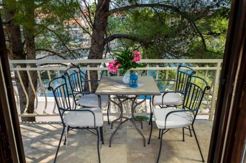 a table with chairs and a vase of flowers on a porch at House Dinka with Pool in Porat