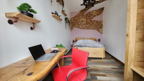 a room with a desk with a laptop and a red chair at Private & Comfortable Apartments in Puttelange-aux-Lacs